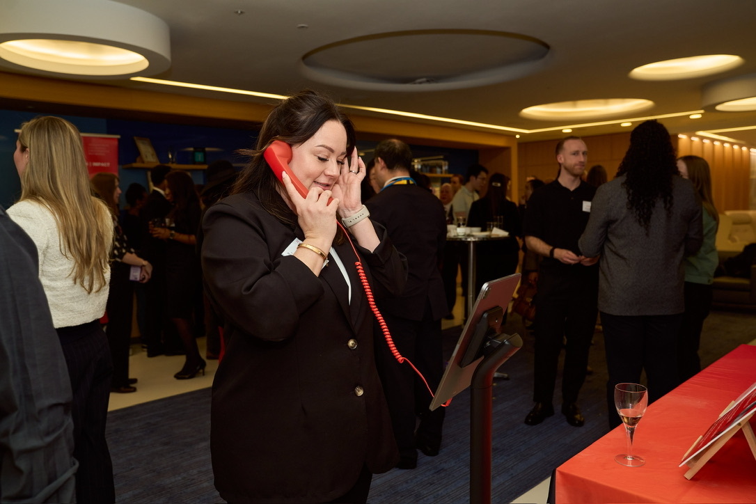 An attendee using the SaySo handset to leave private spoken feedback at an iCAN event